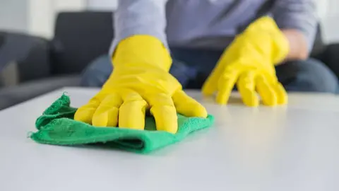 people, housework and housekeeping concept - close up of man hands cleaning table with cloth at home