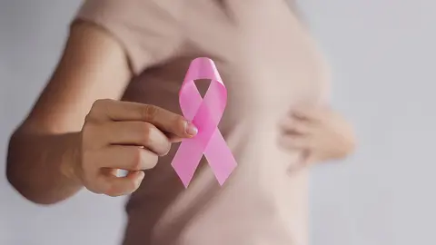 Breast Cancer Awareness Concept.  Health care and medical. Hand of woman holding pink ribbon awareness symbol for endometriosis, Medicine. Prevention Breast.
