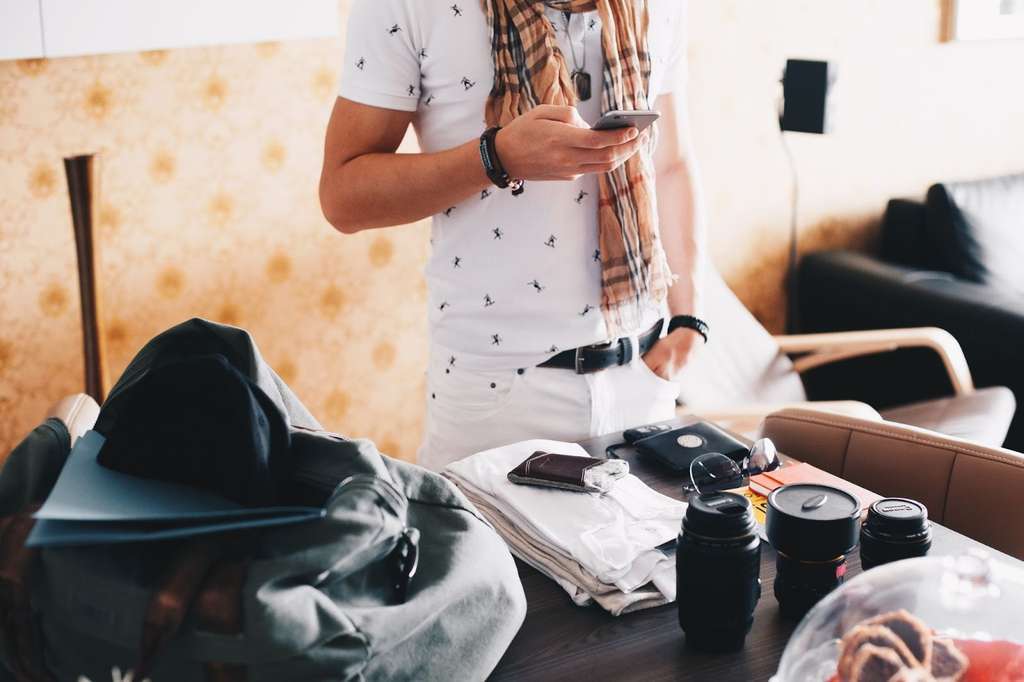 checking-phone-while-packing-for-a-trip-picjumbo-com